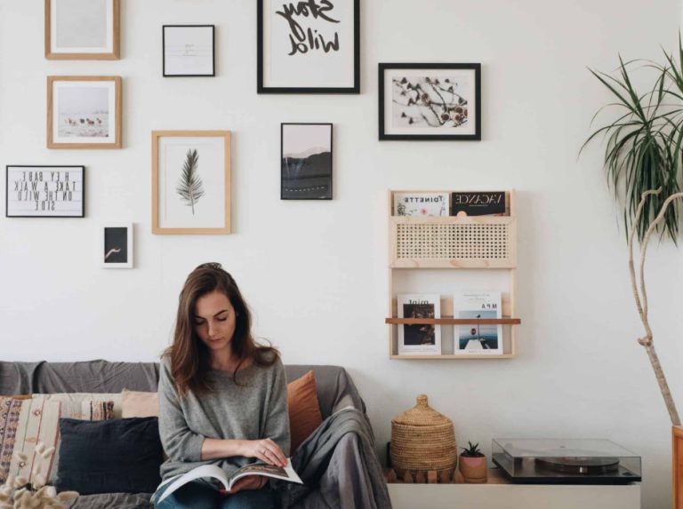 Une femme assise lit un magazine