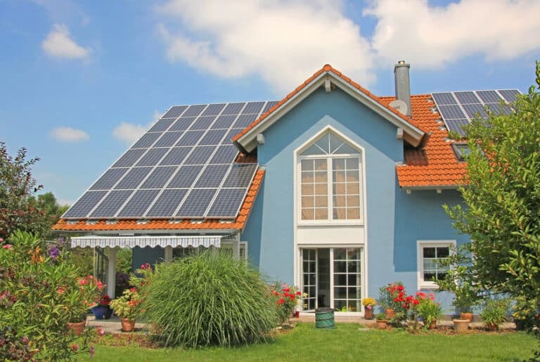 modern new built house and garden, rooftop with solar cells, blu