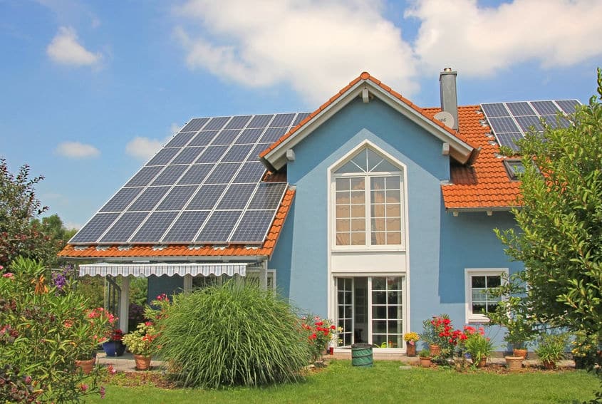 modern new built house and garden, rooftop with solar cells, blu